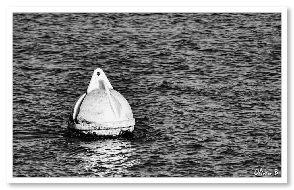 Une bouée d'amarrage blanche symbolisant le rattachement à l'essentiel, dans une photo minimaliste