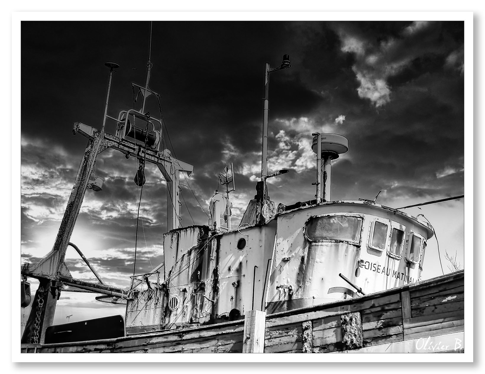 Ancien navire de pêche en bois à la retraite, exposé aux éléments sous un ciel menaçant