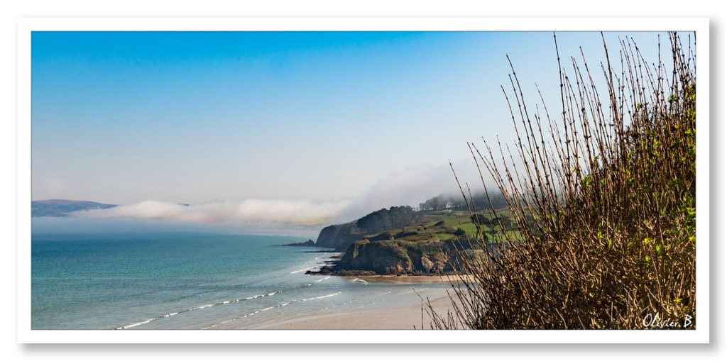 Un nuage fatigué se repose sur les majestueuses falaises surplombant l'océan