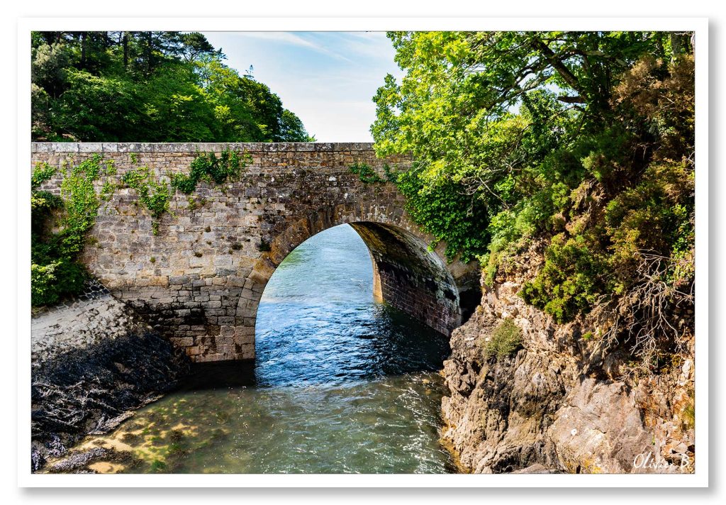 Petit pont de pierre à Audierne, laissant passer l'eau de la rivière vers l'océan